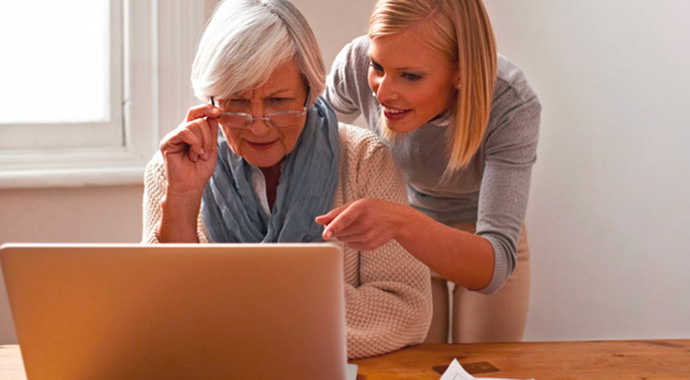 Une femme aidant sa mère sur l'utilisation d'un ordinateur