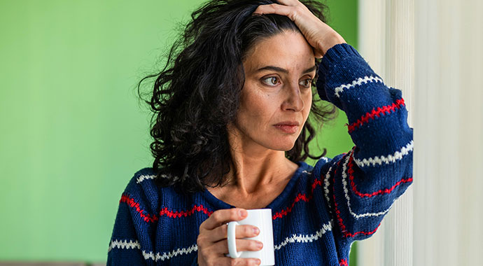 Une femme en proie a des doutes se passe la main dans ses cheveux