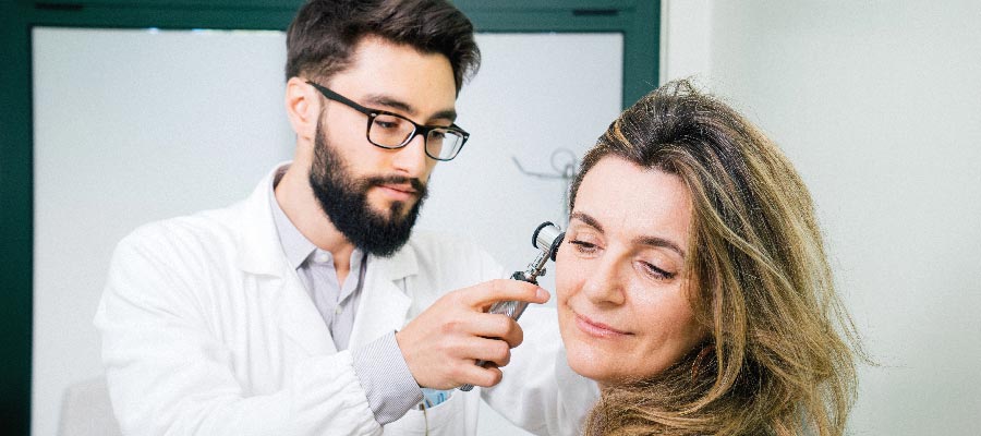 Un audiologiste examine l'oreille d'une femme
